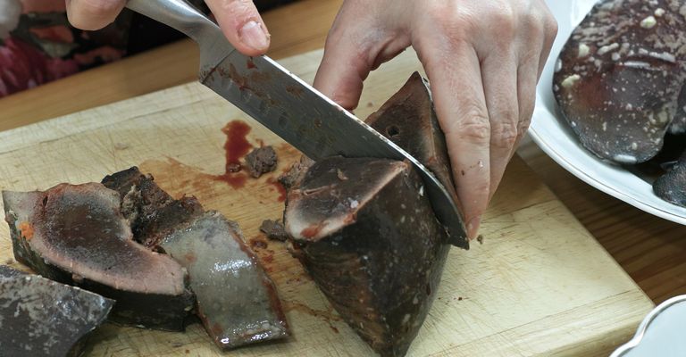 En la cocina polaca, en la mesa polaca. Preparación del paté de hígado. En la foto cortando hígado de cerdo.