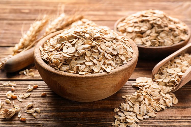Schüssel mit Haferflocken auf Holztisch Schüssel mit Haferflocken auf Holztisch